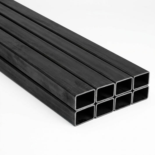 Pila de tubos estructurales rectangulares negros de acero sobre fondo blanco, imagen referencial