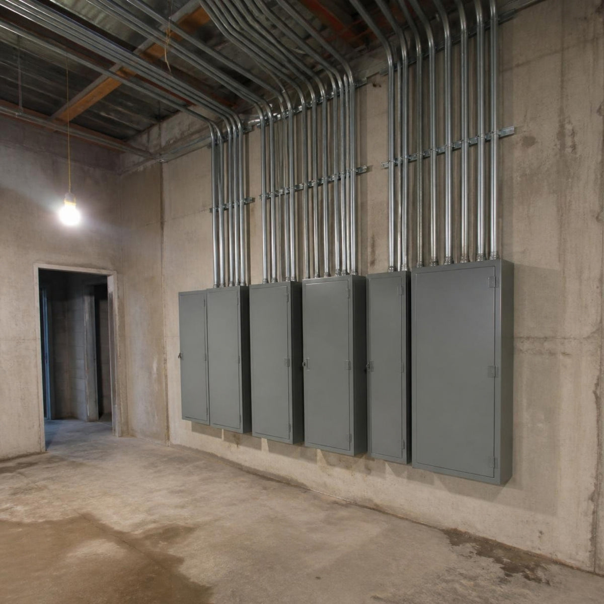 Cople (unión) para tubo conduit EMT — cuarto eléctrico de un edificio comercial en obra