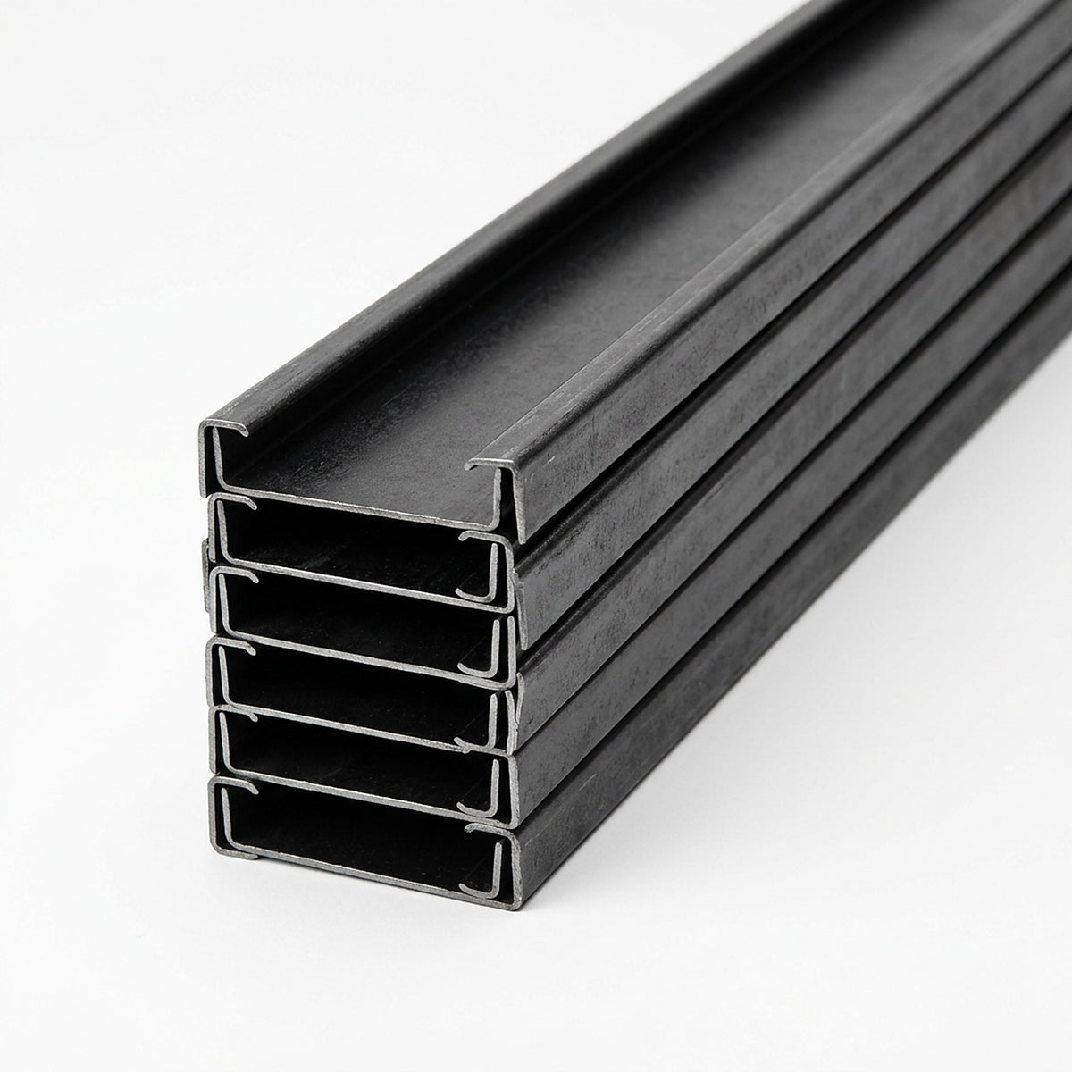 Pila de polines C negros de acero laminado en frío con pestañas visibles, imagen referencial